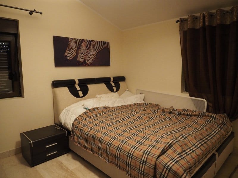 Cozy bedroom with a double bed in a villa, Stoliv, Montenegro: modern furniture and a painting with zebras.