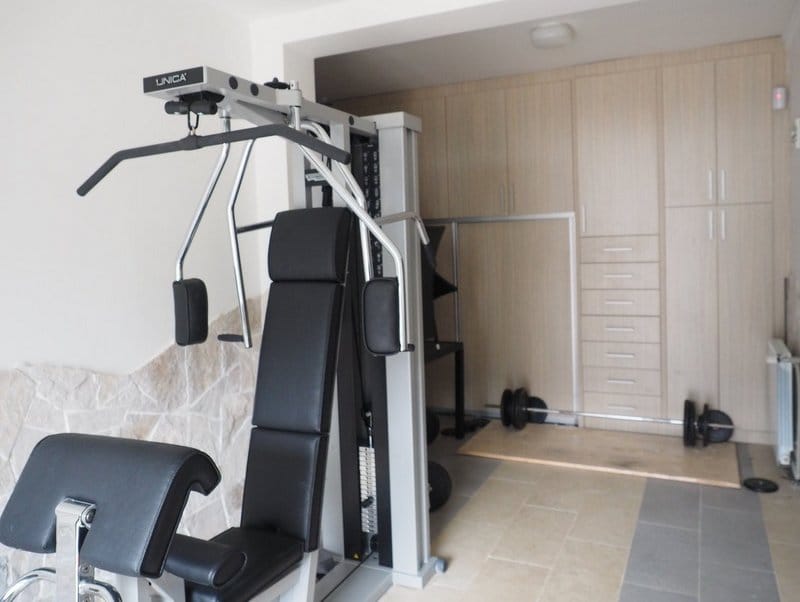 Home gym with an Unica exercise machine and built-in wardrobe in a villa in Stoliv, Montenegro.