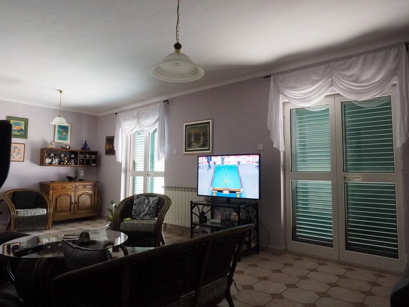 Cozy living room with wicker furniture and access to the terrace in a villa, Dobrota, Montenegro.