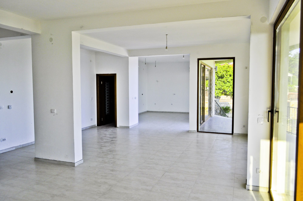 Spacious living room with white finishes and access to the terrace in a villa, Shushan, Montenegro.