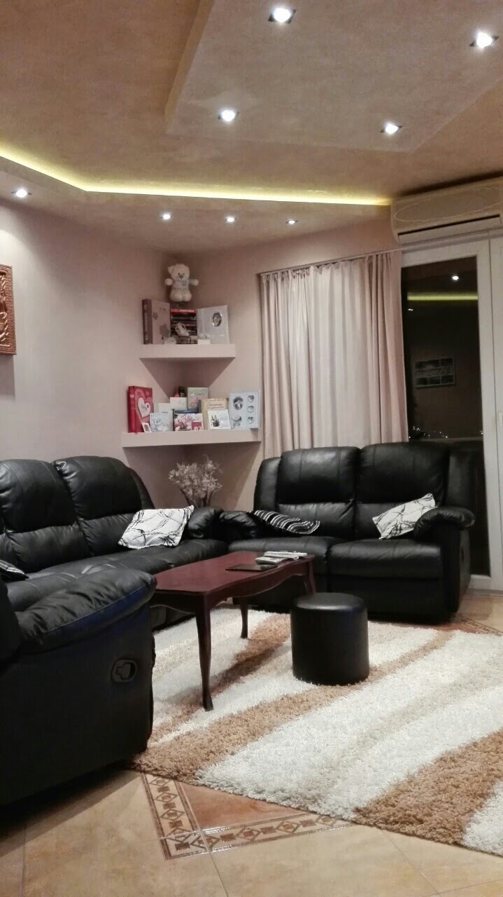 Cozy living room with black leather sofas in an apartment in Kotor, Montenegro: stylish interior with lighting.