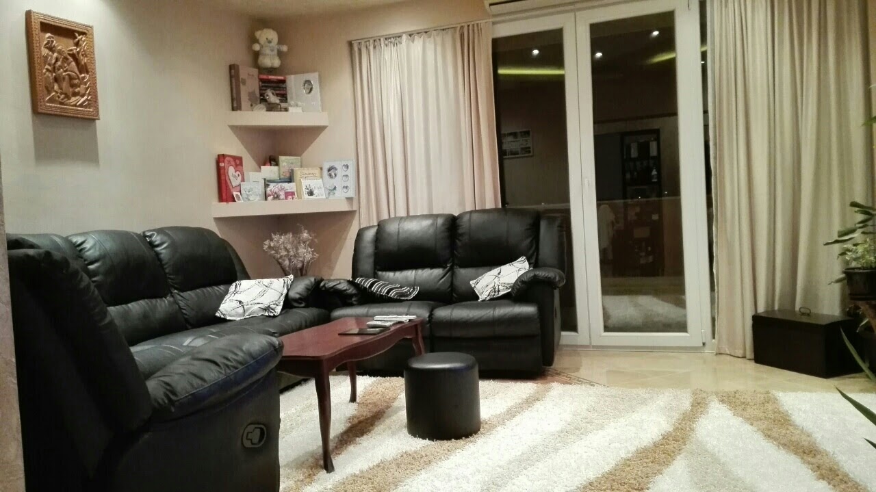 Cozy living room with black leather sofas in an apartment in Kotor, Montenegro: modern interior with panoramic windows.