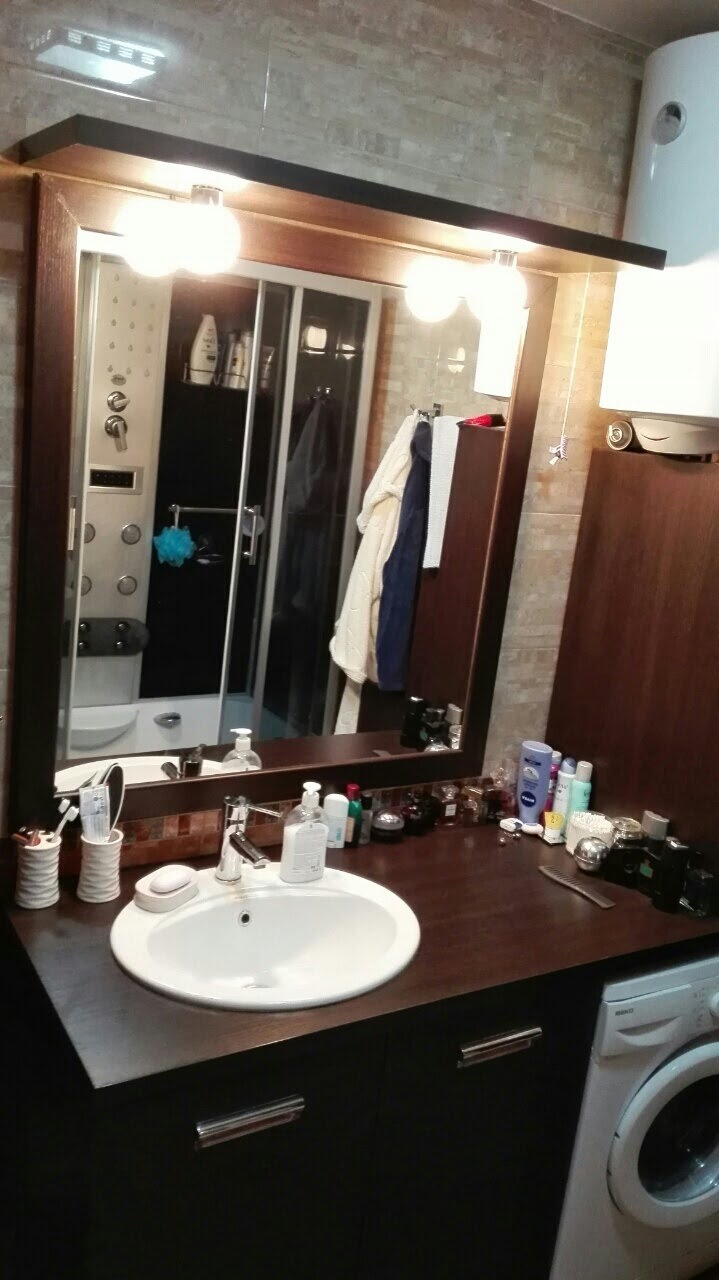 Bathroom in an apartment in Kotor, Montenegro: vanity with sink, large mirror, and a hydromassage shower cabin.