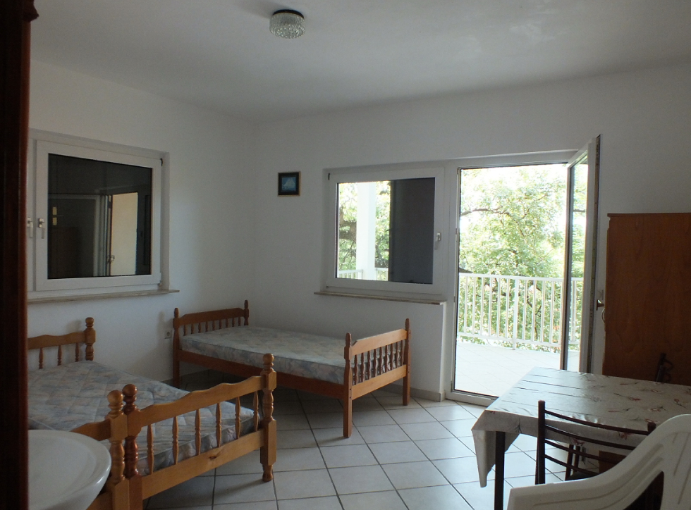 Bright bedroom with two wooden beds and access to a terrace in a house, Bar, Montenegro.