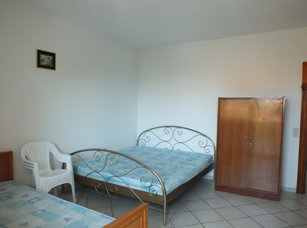 Bedroom in a house in Bar, Montenegro: a double bed with a wrought-iron headboard, a wardrobe, and tiled flooring.