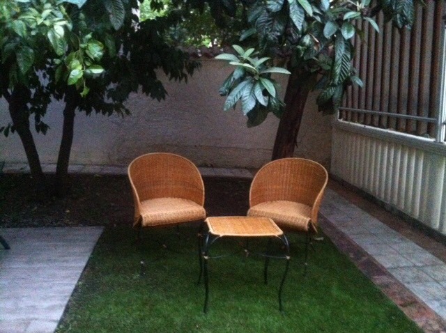 A cozy seating area with wicker chairs and a table in the garden of a private house in Herceg Novi, Montenegro.