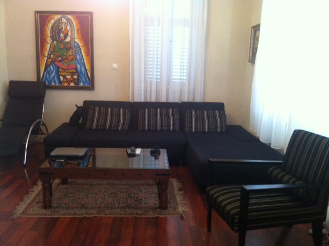 Living room in a house in Herceg Novi, Montenegro: dark sofa, armchair, coffee table, and a painting on the wall.