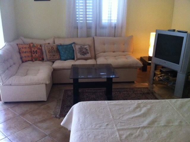 Cozy living room with a corner sofa and TV in a house for sale, Herceg Novi, Montenegro: interior with upholstered furniture.