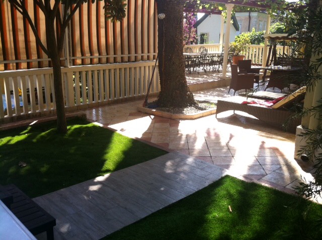Cozy terrace with garden furniture and lawn by the house in Herceg Novi, Montenegro: a relaxation area with sun loungers and a canopy.