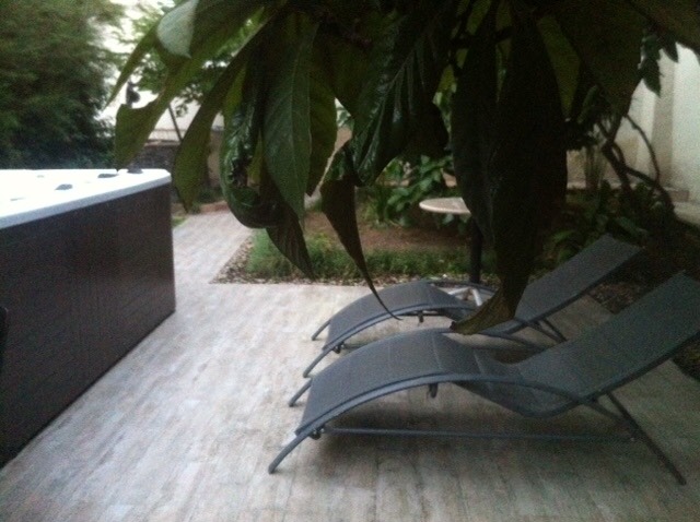 Relaxation area with a jacuzzi and sun loungers on the terrace of a house in Herceg Novi, Montenegro, surrounded by garden greenery.