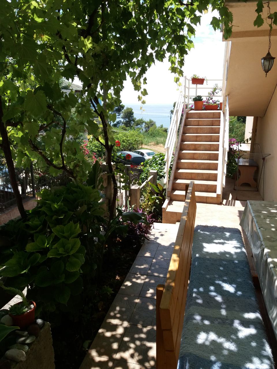 Cozy terrace with a sea view and a vineyard at a house in Bar, Montenegro, featuring stairs to the second floor.