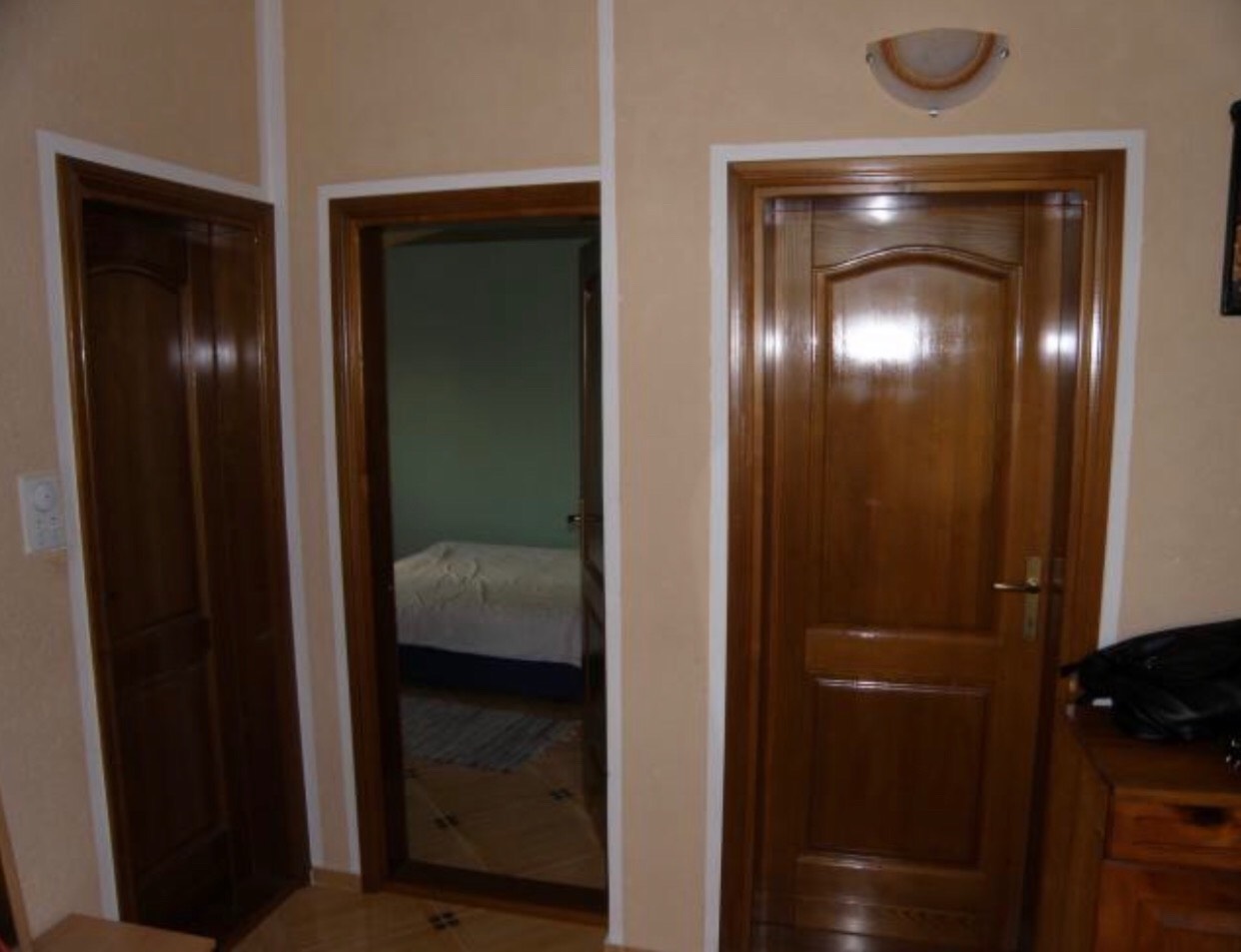 Natural wood interior doors in a house in Bar, Montenegro, view of the bedroom with a bed.