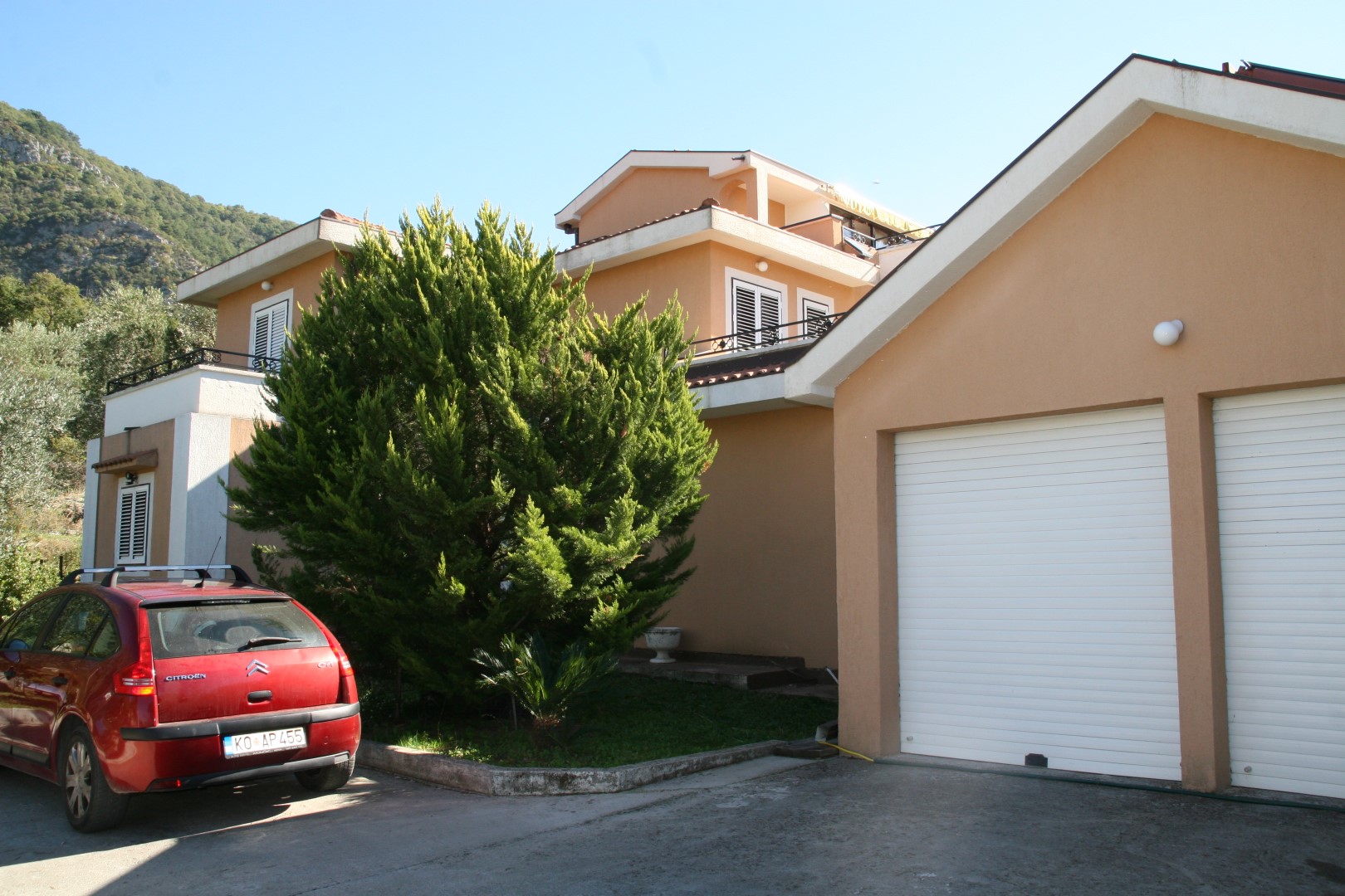 Two-story villa with a garage and garden in Kavac, Bay of Kotor, Montenegro: exterior of the house with parking.