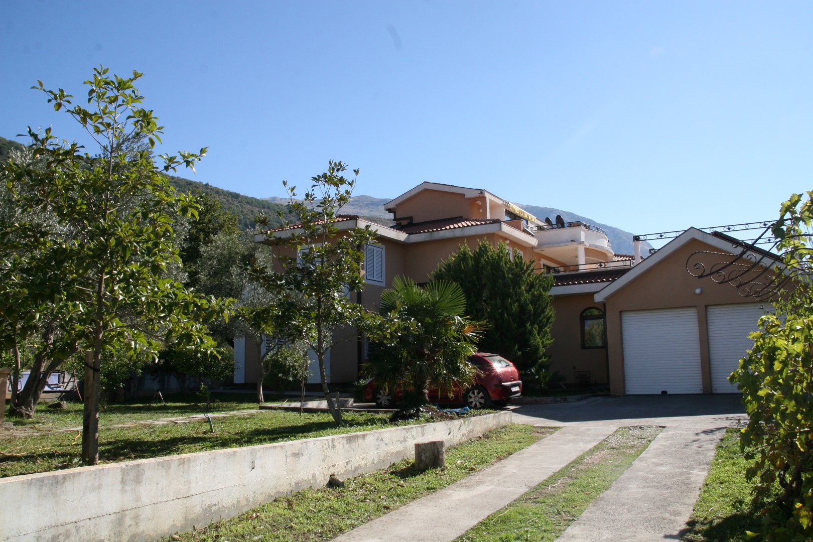 Two-story villa with a garage and garden in Kavac, Bay of Kotor, Montenegro. View of the house with the surrounding grounds.