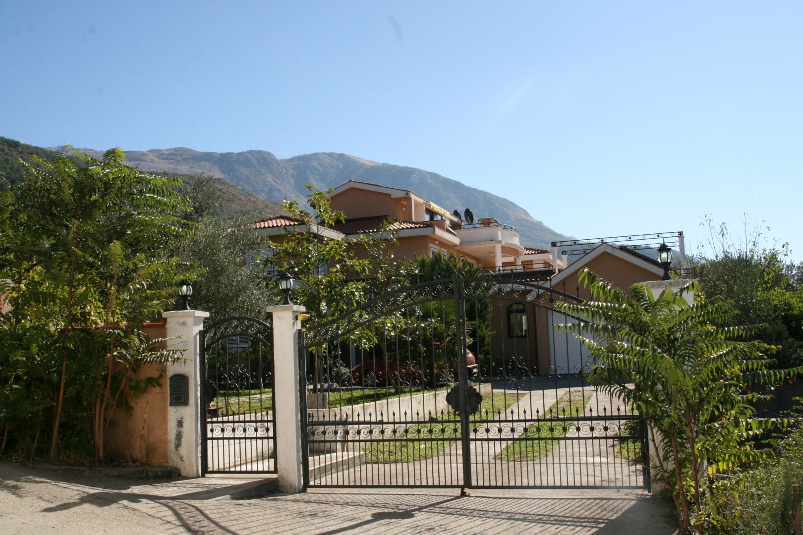 Two-story villa with wrought-iron gates and mountain views in Kavac, Bay of Kotor, Montenegro.
