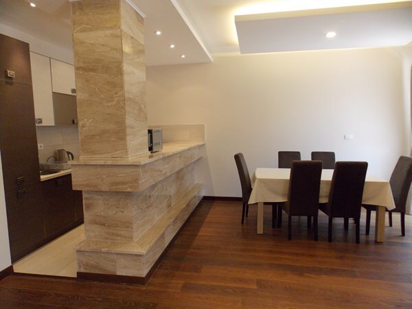 Modern living room with dining area and marble bar counter in an apartment in Budva, Montenegro.