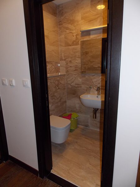 Modern bathroom with white fixtures and tiled finishes in an apartment in Budva, Montenegro.