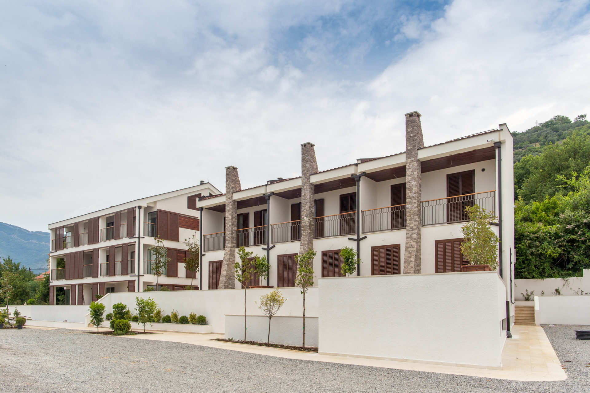 Modern residential complex with terraces and stone cladding in Tivat, Montenegro: view of the building facades with balconies.