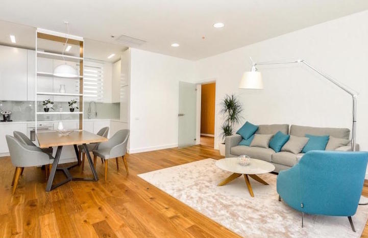 Modern living room with kitchen in an apartment in Kamenovo, Montenegro: bright interior, soft furniture, and dining area.