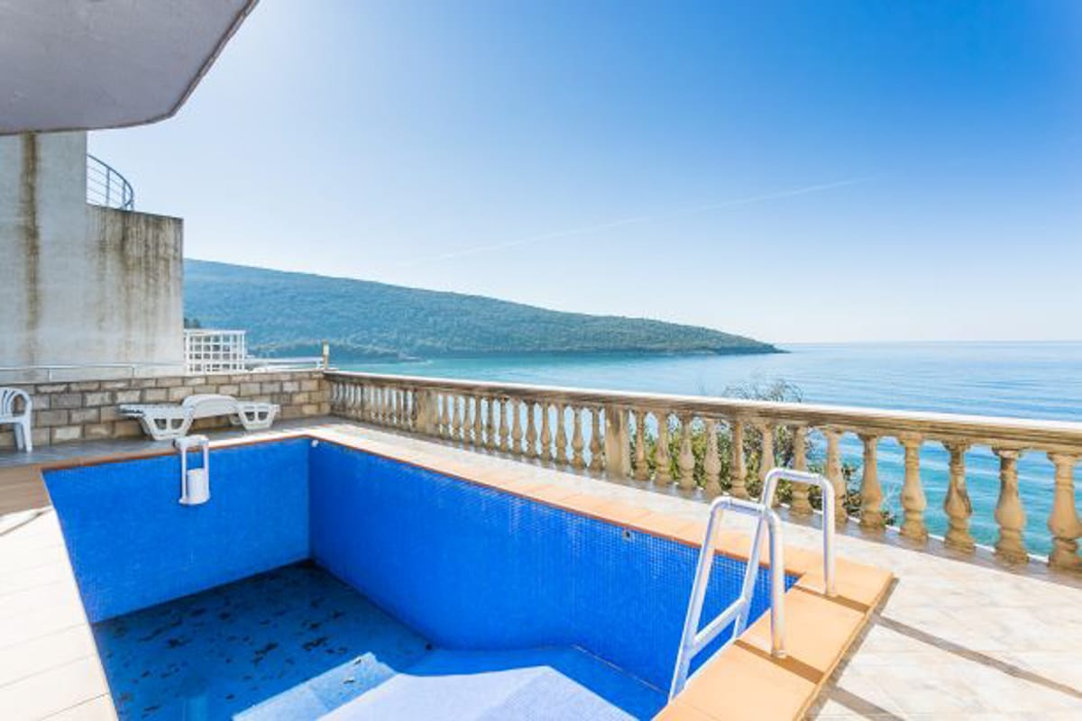 Terrace with a pool and panoramic sea view in a house, Kruče, Montenegro. Tiled finish and sun loungers.