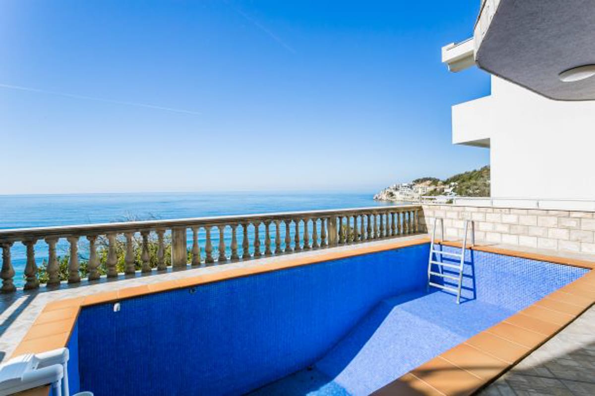 Open-air pool on the terrace of a house in Kruče, Montenegro, with panoramic views of the Adriatic Sea and a balustrade.