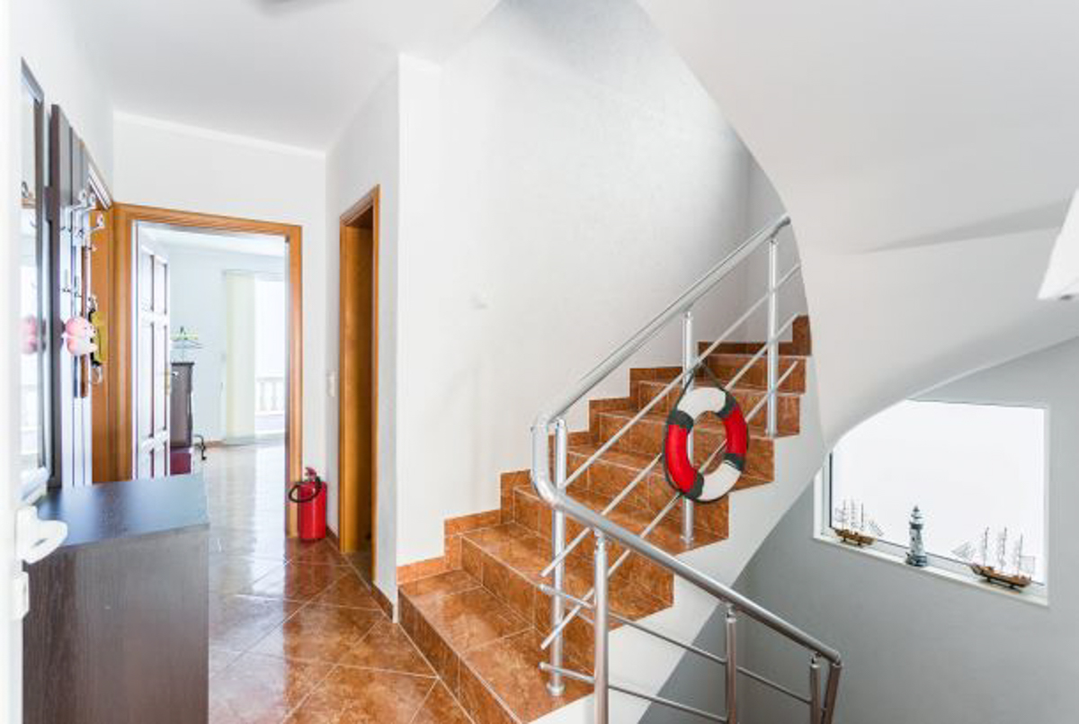 Staircase with tiled finish and metal railings in a house in Kruče, Montenegro, with nautical decor in the interior.