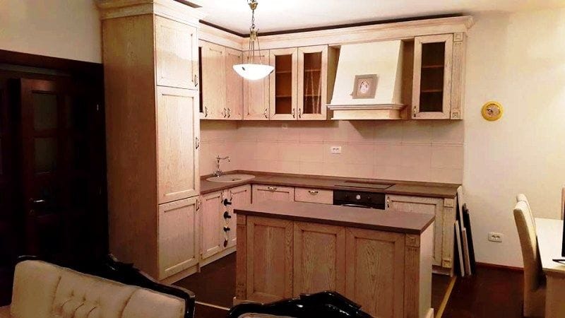 Bright kitchen with wooden cabinetry and an island in a villa in Krimovica, Montenegro. Classic-style interior.