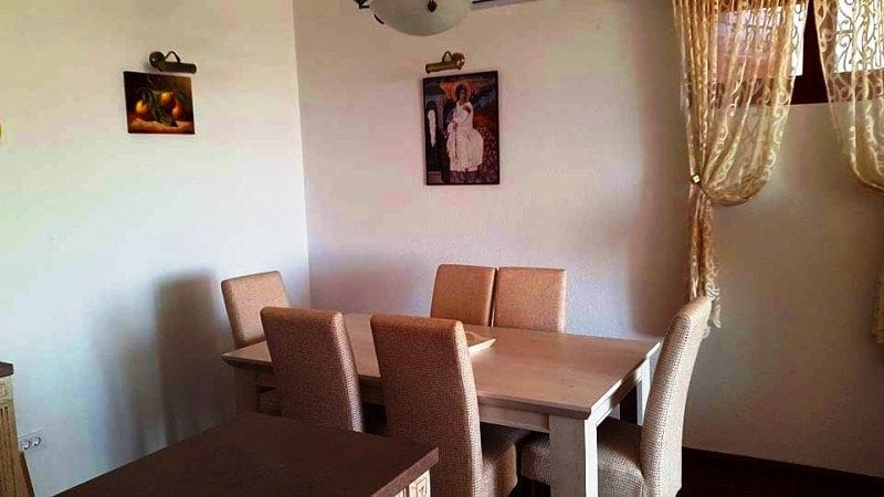 Cozy dining area with a wooden table and chairs in the villa living room in Krimovica, Montenegro.