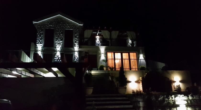 Two-story villa in Krimovica, Montenegro: night facade lighting, stone cladding, and a terrace with panoramic windows.