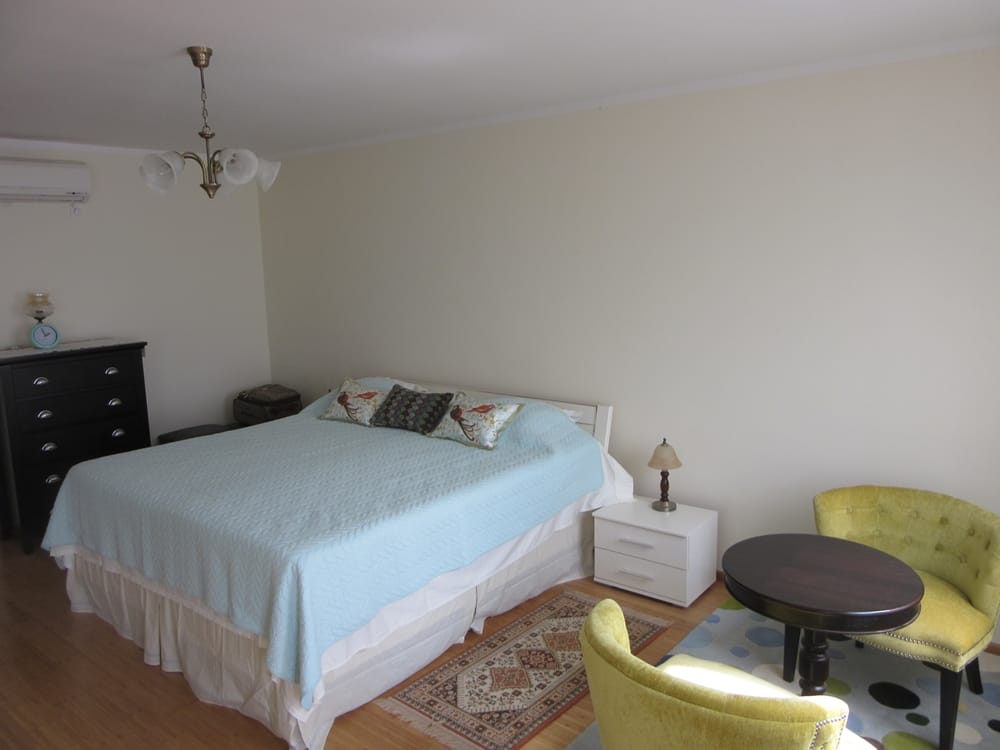 Cozy bedroom with a double bed and sitting area in a villa in Reževići, Montenegro: bright interior and furniture.