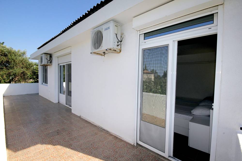 Spacious terrace of a house in Reževići, Budva Riviera, Montenegro, with access from the bedroom and air conditioners on the facade.