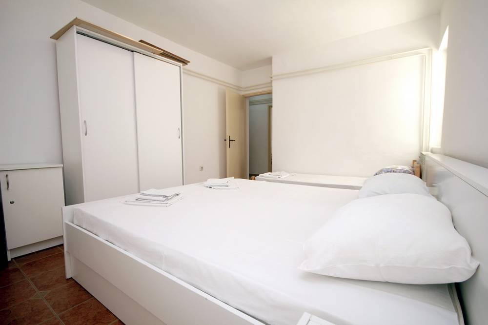 Bright bedroom with a double bed and wardrobe in a house on the Budva Riviera, Montenegro.