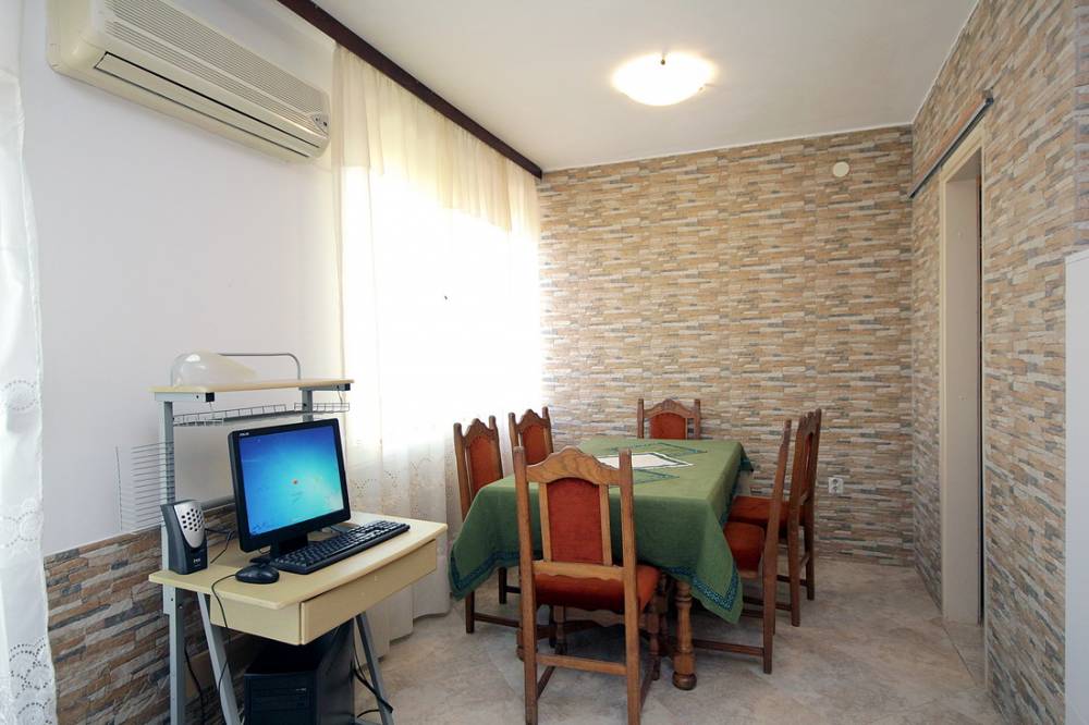 Living room with dining area and computer desk in a house on the Budva Riviera, Montenegro. Stone finish.