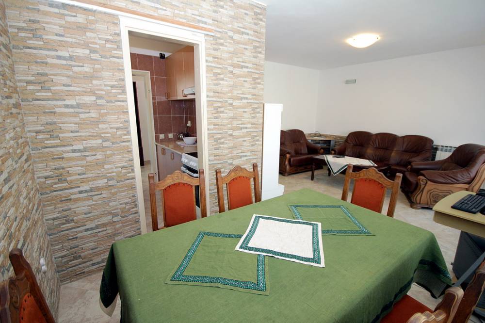 Living room with dining area and stone finishes in a house, Reževići, Budva Riviera, Montenegro.