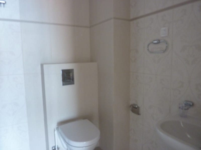 Modern bathroom with a wall-mounted toilet and light-colored tiles in an apartment in Pržno, Montenegro.