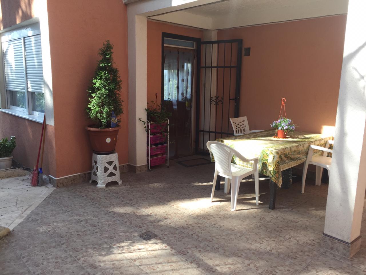 Cozy terrace with a dining area and garden furniture by the house in Shushan, Montenegro. View of the entrance area and courtyard.