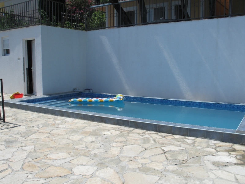 Outdoor pool with mosaic finish and stone terrace by a private house in Sutomore, Montenegro.