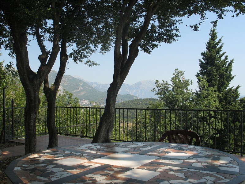 Terrace with a mosaic table and panoramic views of the mountains and greenery in a house, Sutomore, Montenegro.