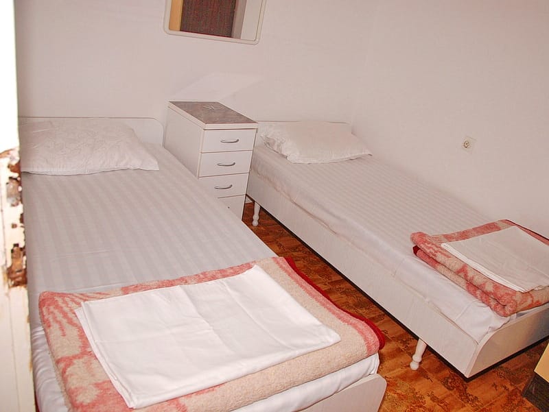 Bedroom with two single beds and a nightstand in a house for sale, Igalo, Montenegro.