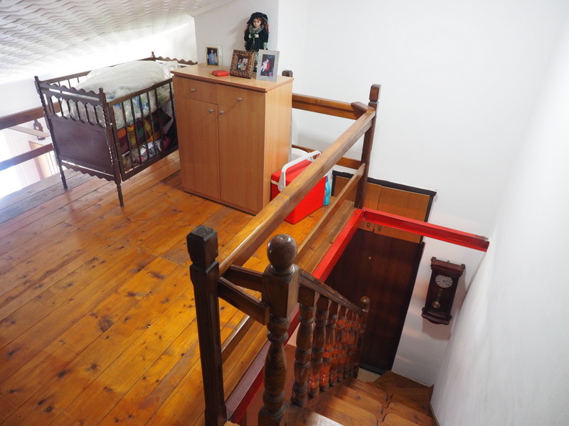 Wooden staircase and mezzanine in an apartment in Bar, Montenegro: interior with wooden floors and antique furniture.
