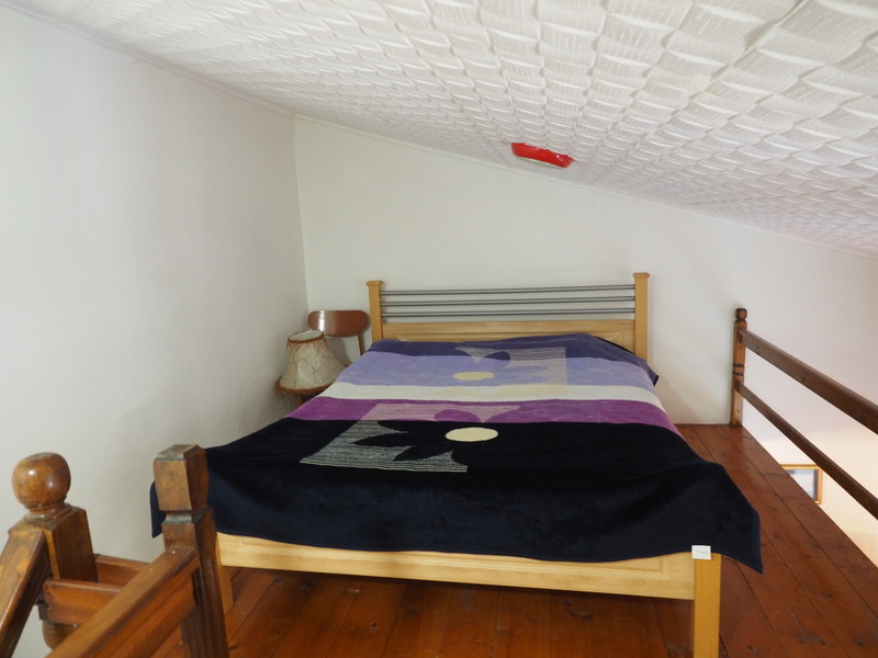 Sleeping area on the attic floor of an apartment in Bar, Montenegro: double bed, wooden floor, and railing.