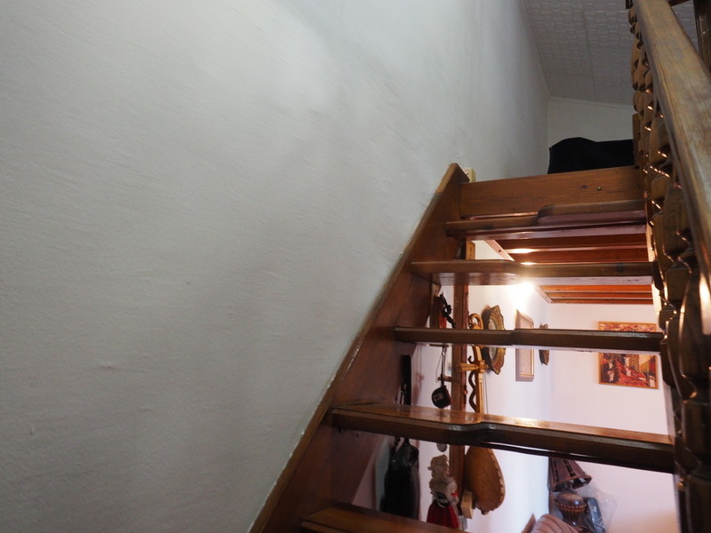 Wooden staircase to the second level in an apartment, Bar, Montenegro. Interior with white walls and decor.