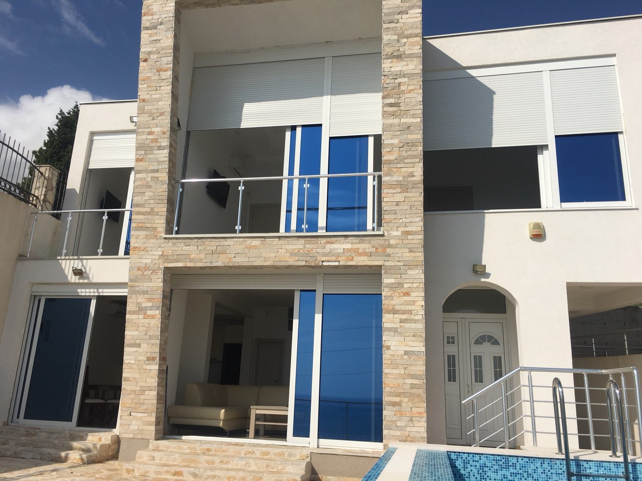 Modern villa with a pool and panoramic windows in Shushan, Bar Riviera, Montenegro. Stone and glass facade.
