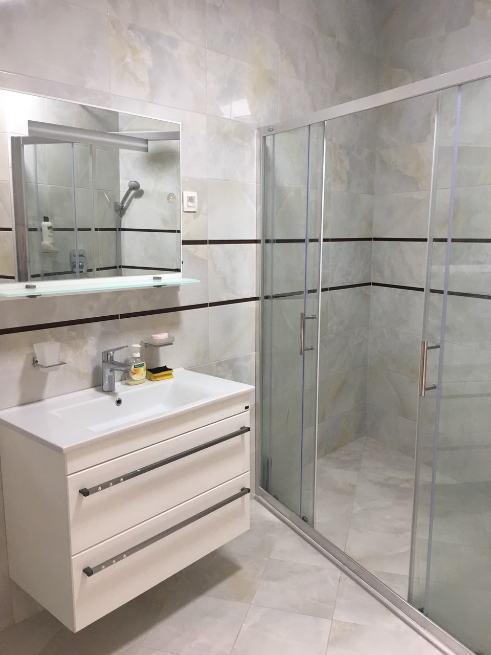 Modern bathroom with a shower cabin and light-colored tiles in a house on the Bar Riviera, Montenegro.