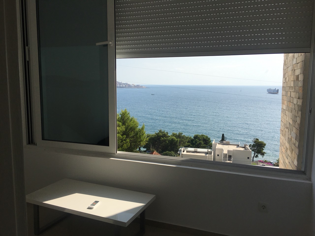Sea view from the living room of a house in Shushan, Bar Riviera, Montenegro: white furniture and a panoramic window.