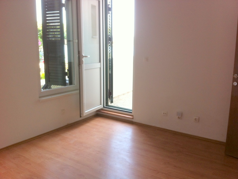 Bright living room with laminate flooring and access to the terrace in an apartment, Herceg Novi, Montenegro.