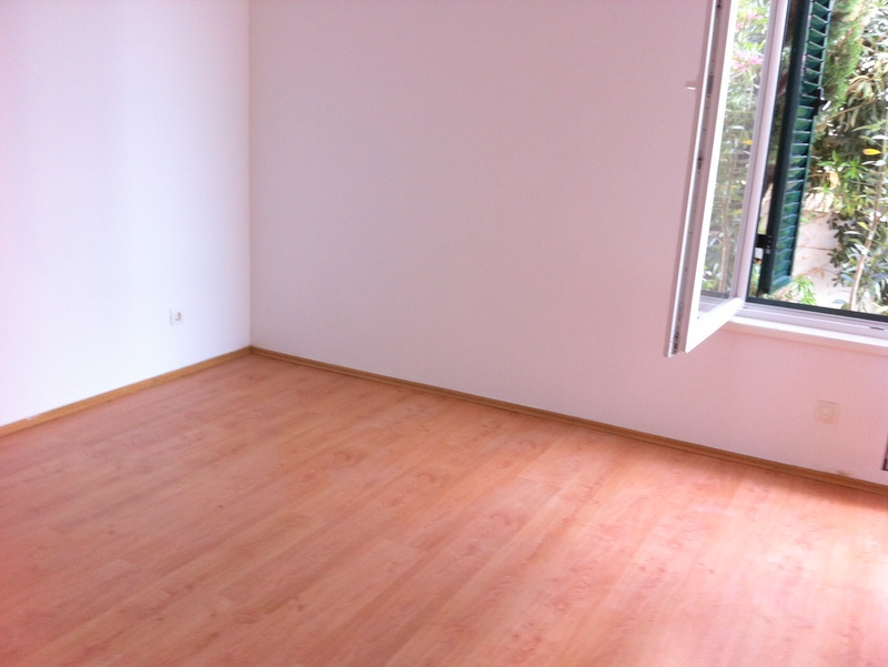 Bright bedroom with laminate flooring and a window overlooking greenery in an apartment in Herceg Novi, Montenegro.