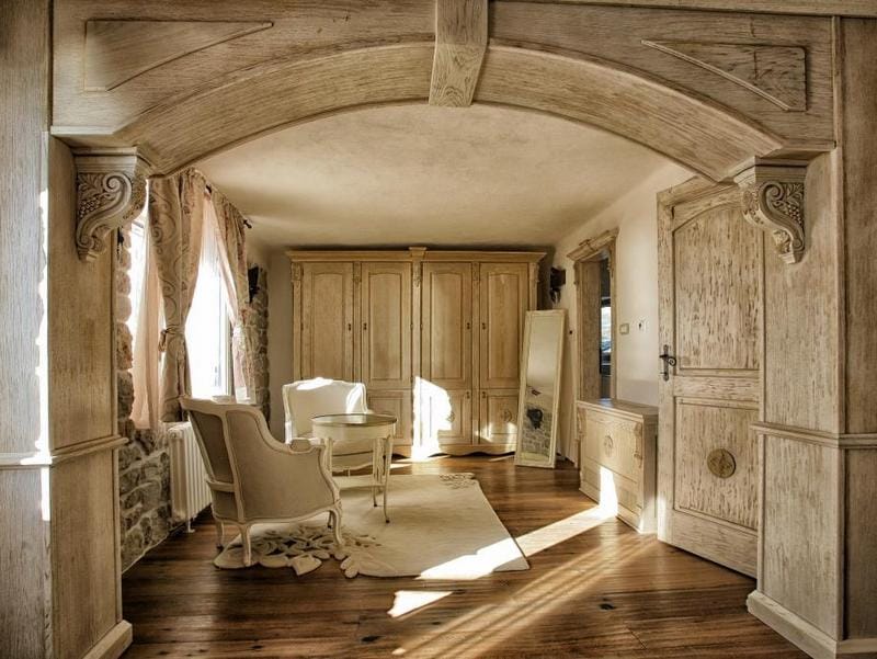 Villa living room in Reževići, Montenegro: interior with wood paneling, an arched opening, light-colored furniture, and a stone wall.