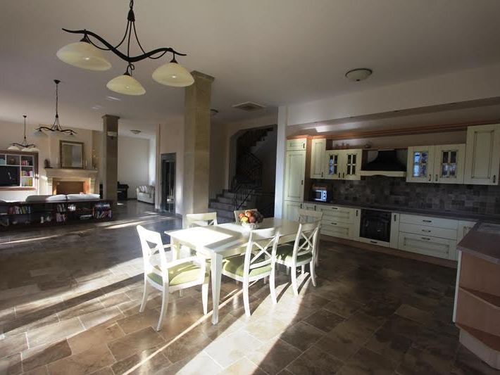 Spacious kitchen-dining room with stone flooring and a classic kitchen set in a villa in Petrovac, Montenegro.