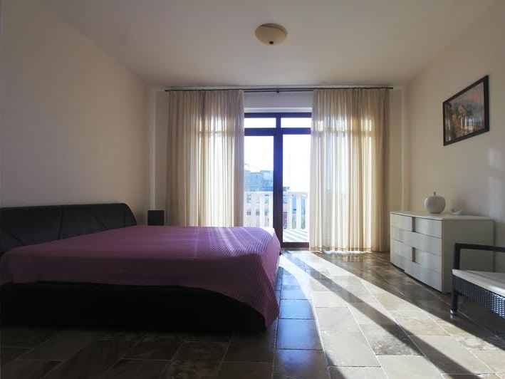 Bright bedroom with a double bed and access to the balcony in a villa in Petrovac, Montenegro.